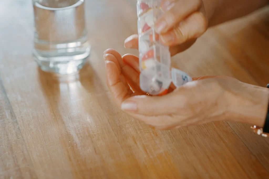 Optimal vitamin timing guide showing clock face surrounded by vitamin supplements, meal timing icons, and daily schedule for maximum absorption